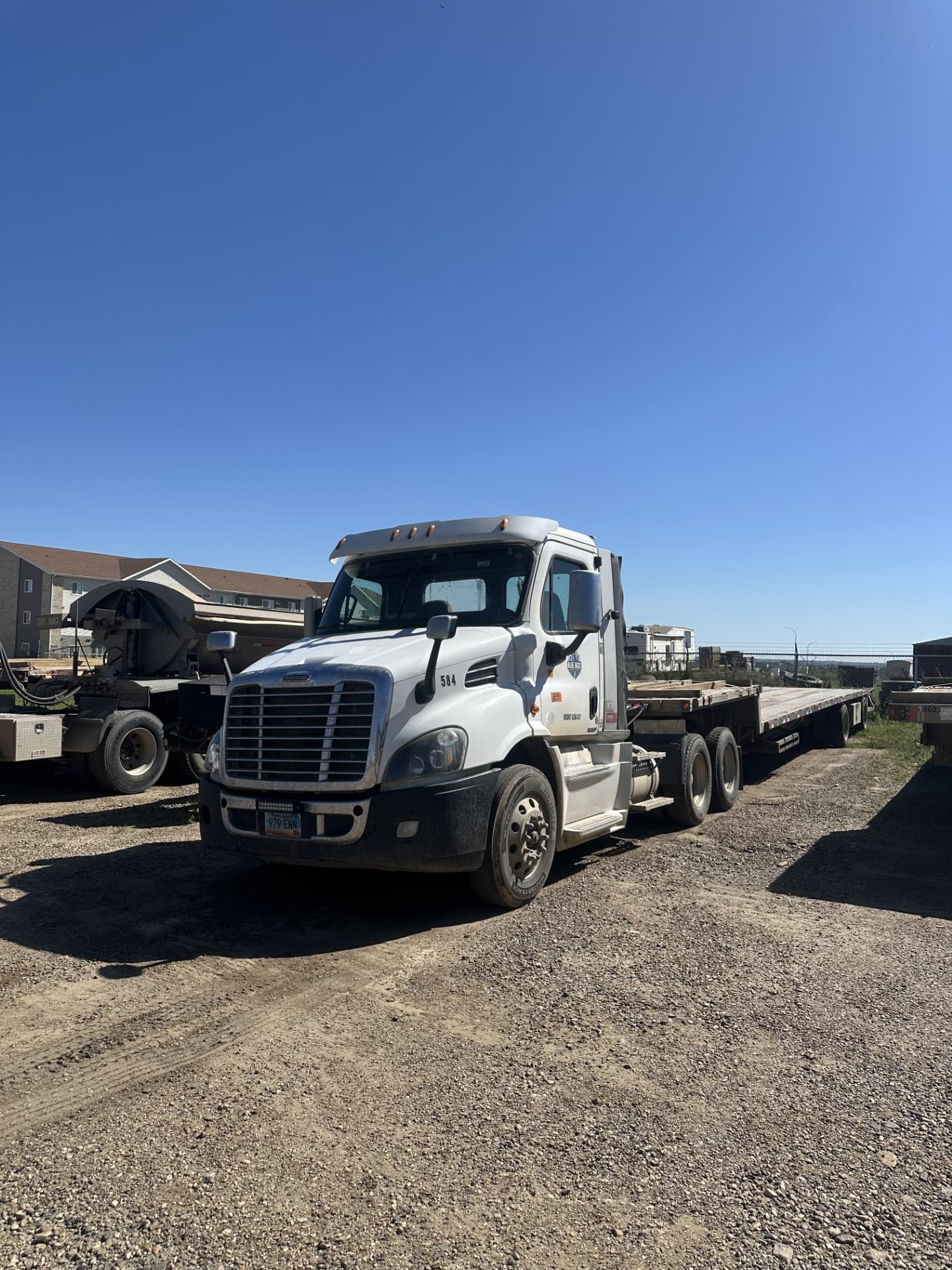 Blue Rock Freightliner with a flatbed trailer, unit 584